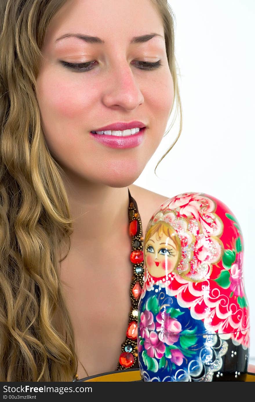 Gorgeous young lady with a wooden coorful doll. Gorgeous young lady with a wooden coorful doll