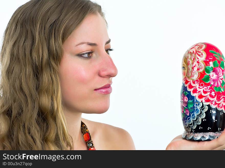 Gorgeous young lady with a wooden coorful doll. Gorgeous young lady with a wooden coorful doll