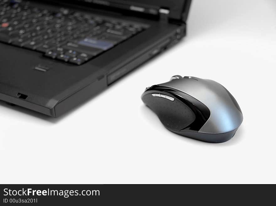 Modern black notebook computer on white background with computer mouse