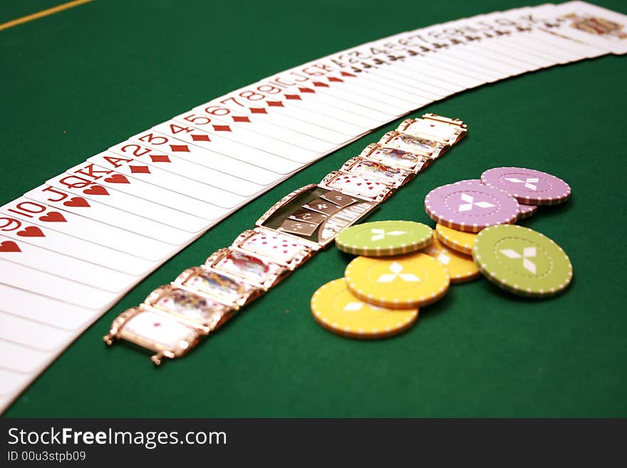 Cards, gold bracelet and chips on a table. Cards, gold bracelet and chips on a table