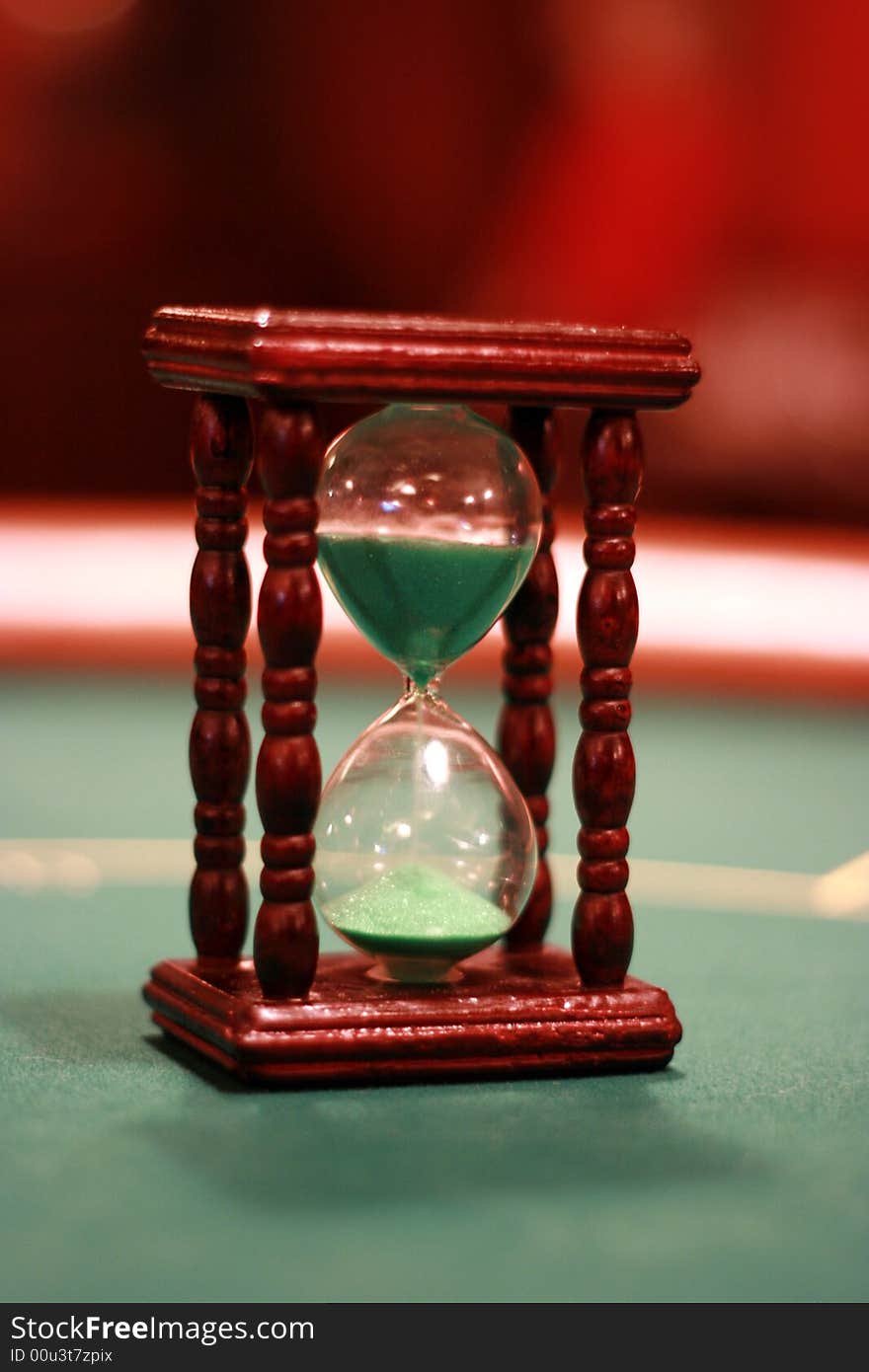 Sand-glass on a green poker table