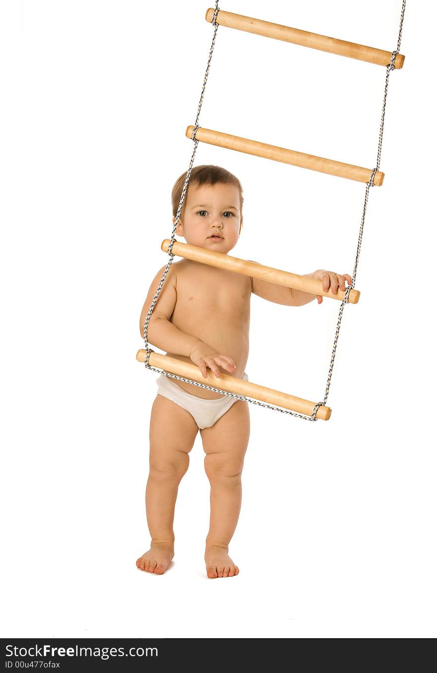 A little boy trying to climb a rope-ladder. A little boy trying to climb a rope-ladder