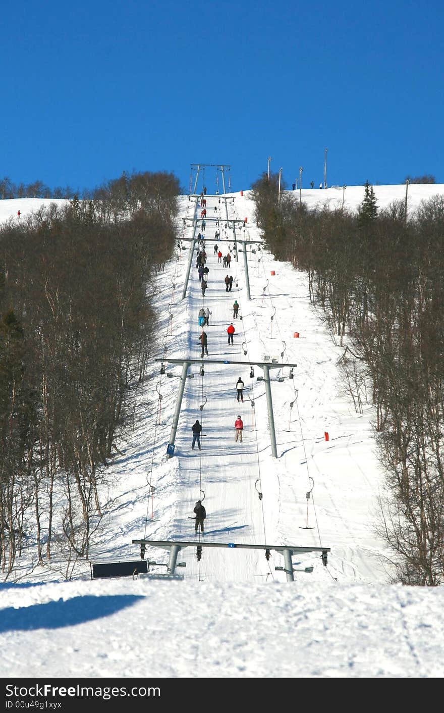 Tourists being transported uphill in a ski lift
