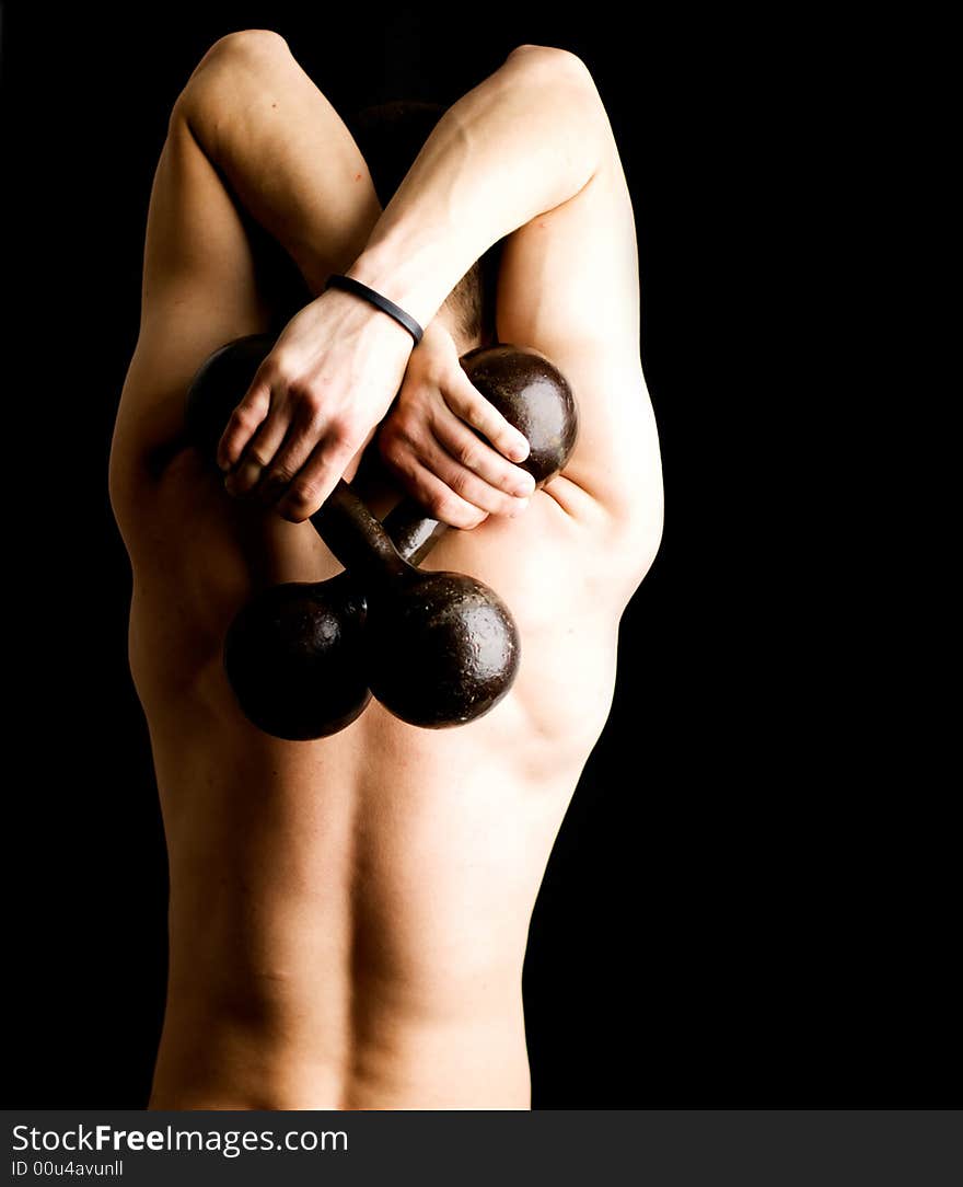 Man with two dumbbells. View from back, isolated on black.