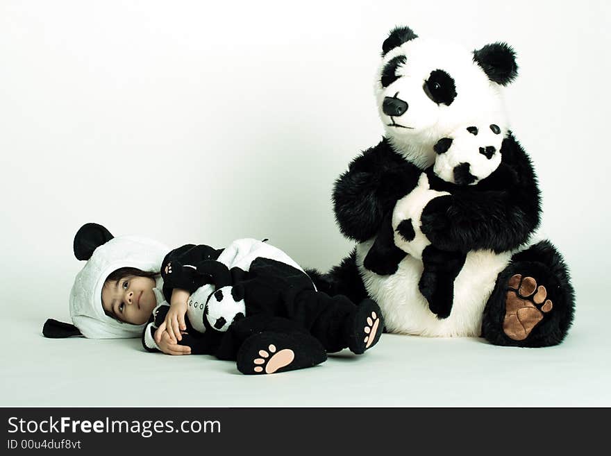 Child wearing a panda costume holding a little baby panda. Child wearing a panda costume holding a little baby panda