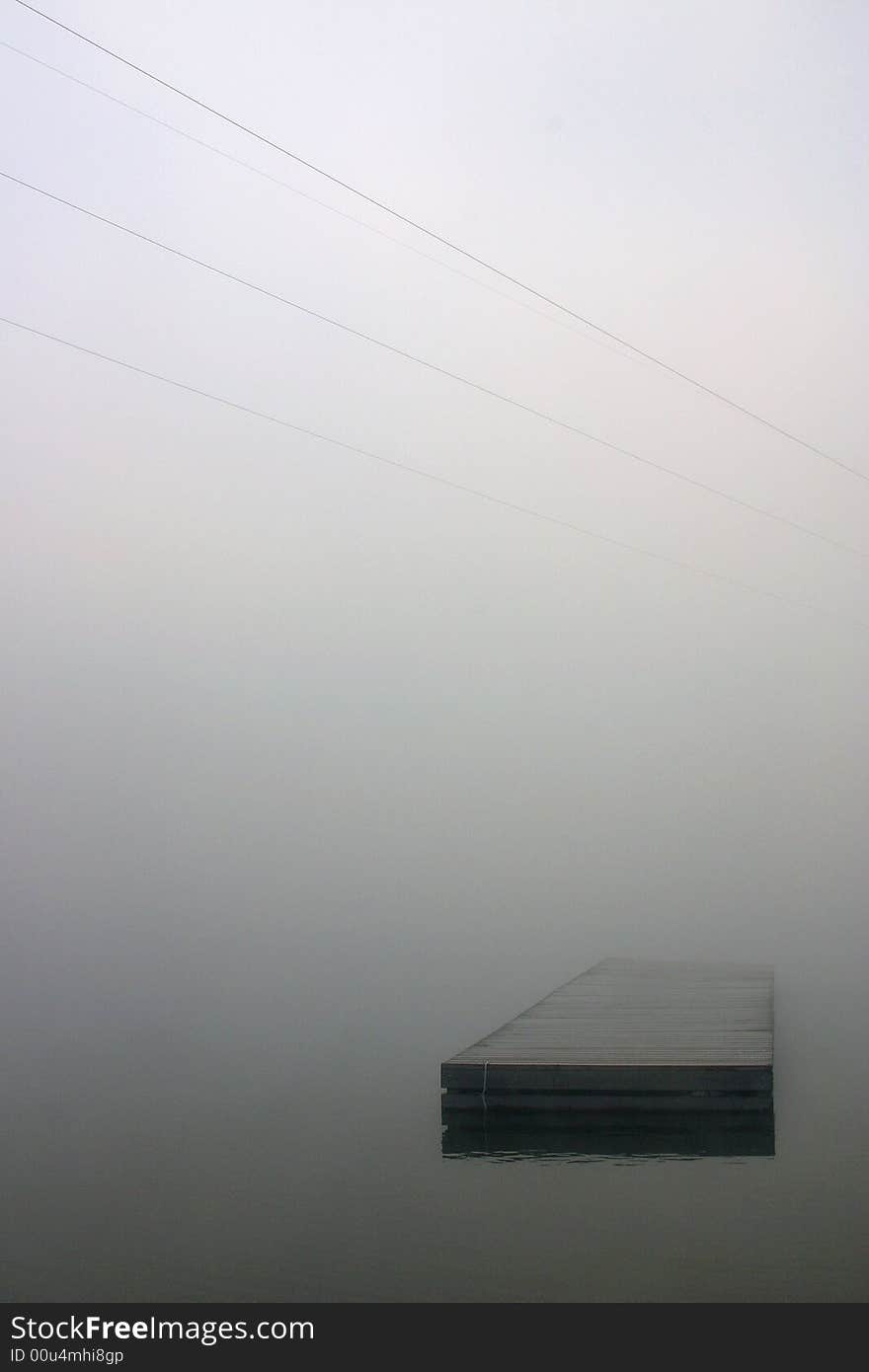 A dock is shrouded by an early morning fog. A dock is shrouded by an early morning fog.