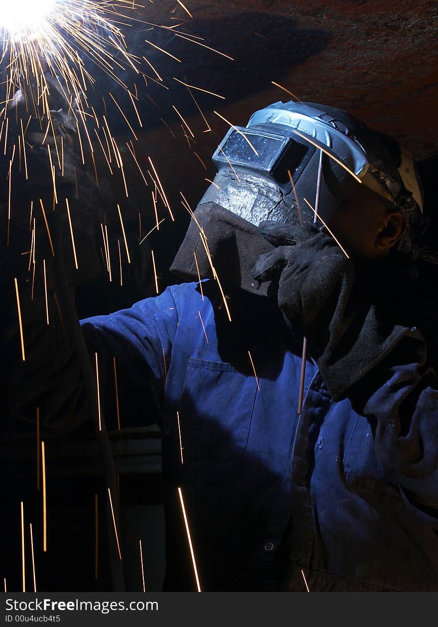 A welder working at shipyard at night. A welder working at shipyard at night