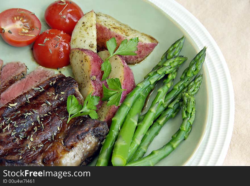 Grilled steak with roasted potatoes, tomatoes, and asparagus. Grilled steak with roasted potatoes, tomatoes, and asparagus.