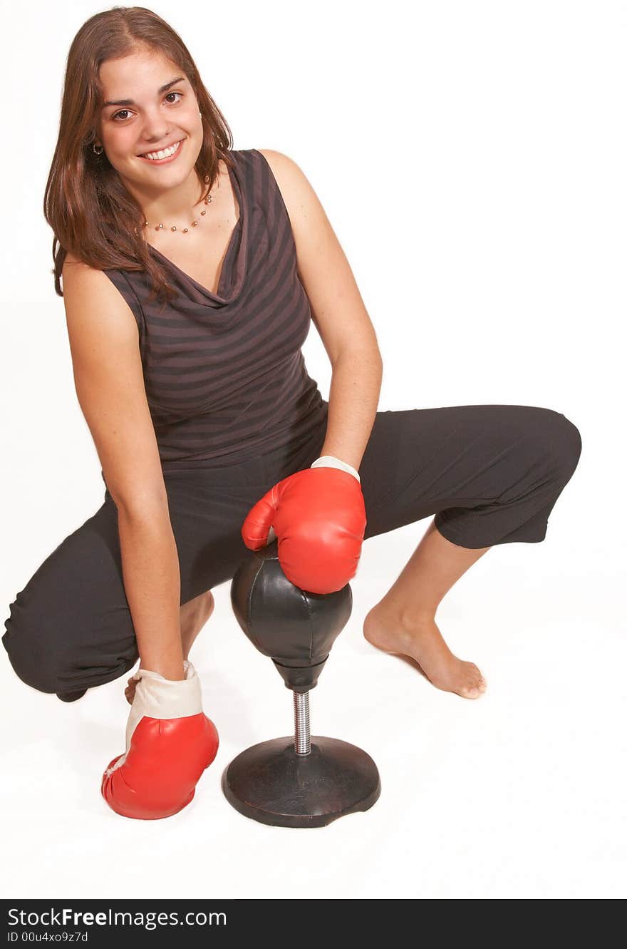 Healthy young woman in red boxing gloves sitting with glove covered hands and smiling her guard up at a boxing workout. Healthy young woman in red boxing gloves sitting with glove covered hands and smiling her guard up at a boxing workout.