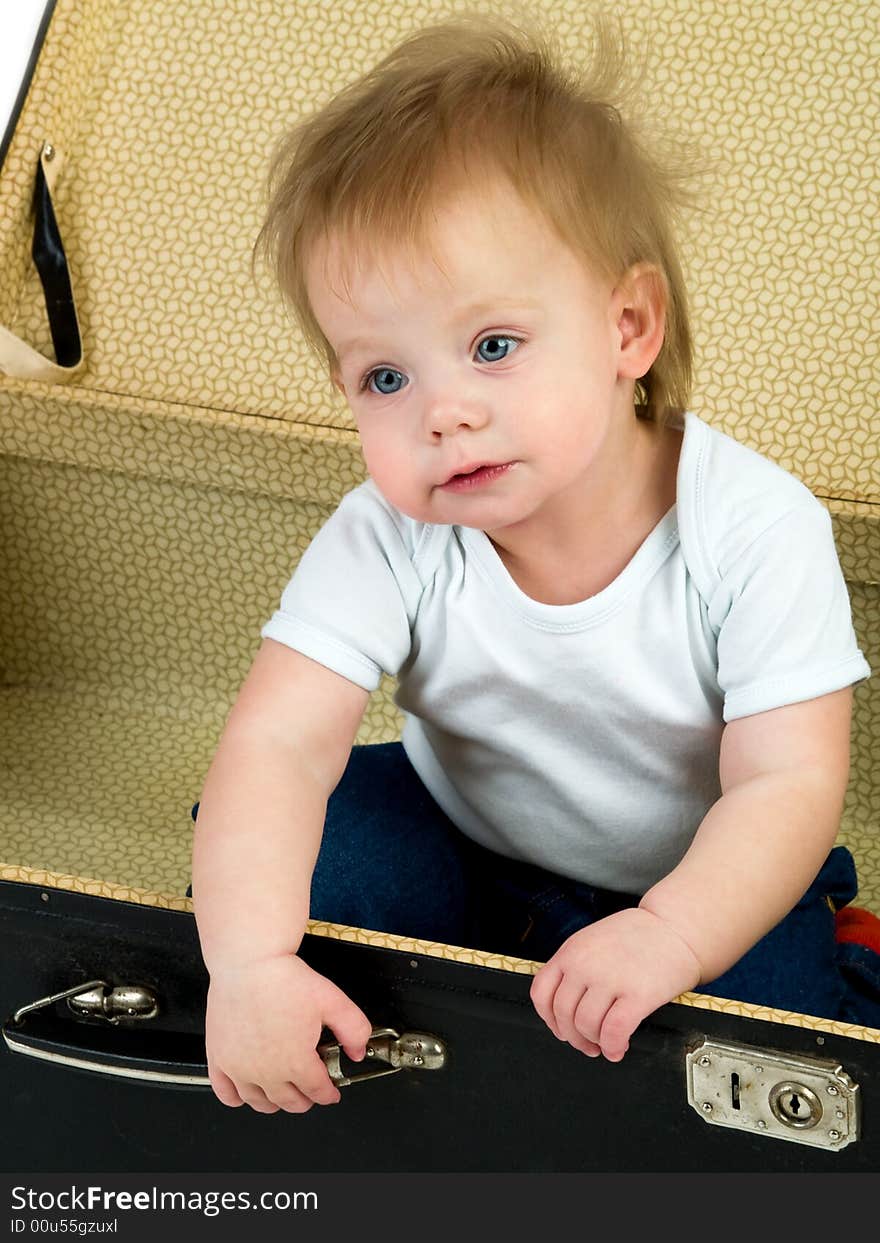 Small child sitting in a suitcase isolated on white. Small child sitting in a suitcase isolated on white