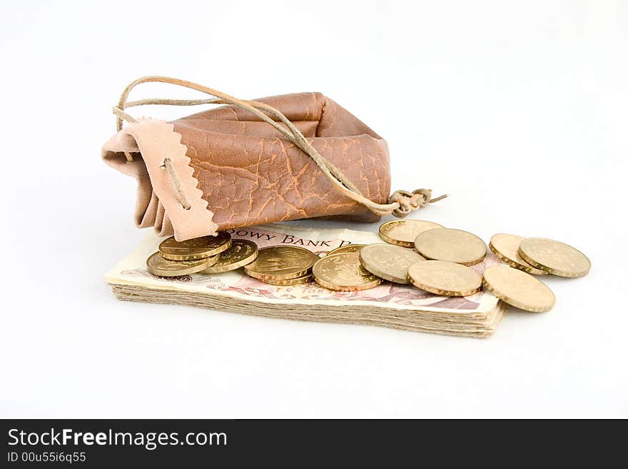 A brown leather pouch with gold coins and wad of banknotes isolated on white background. A brown leather pouch with gold coins and wad of banknotes isolated on white background.