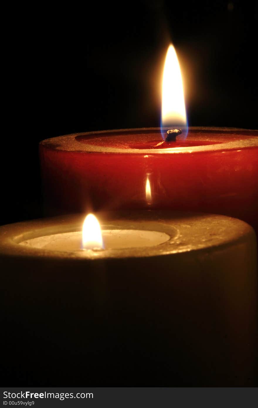 Two candles burning against a dark background.