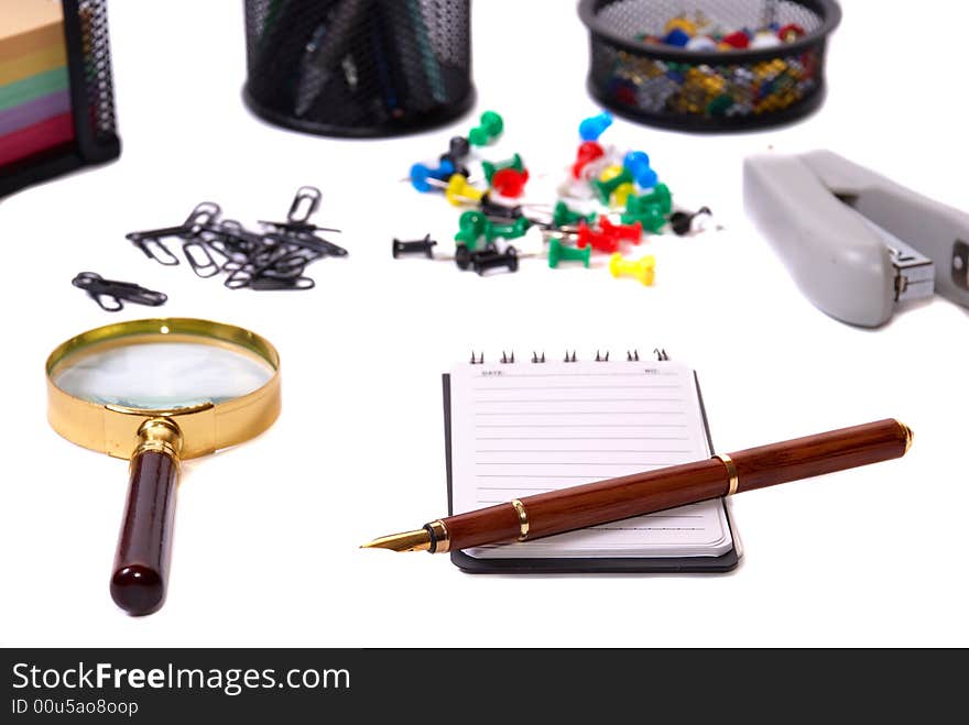 Office tools Magnifier, paper clips, a notebook, pencils