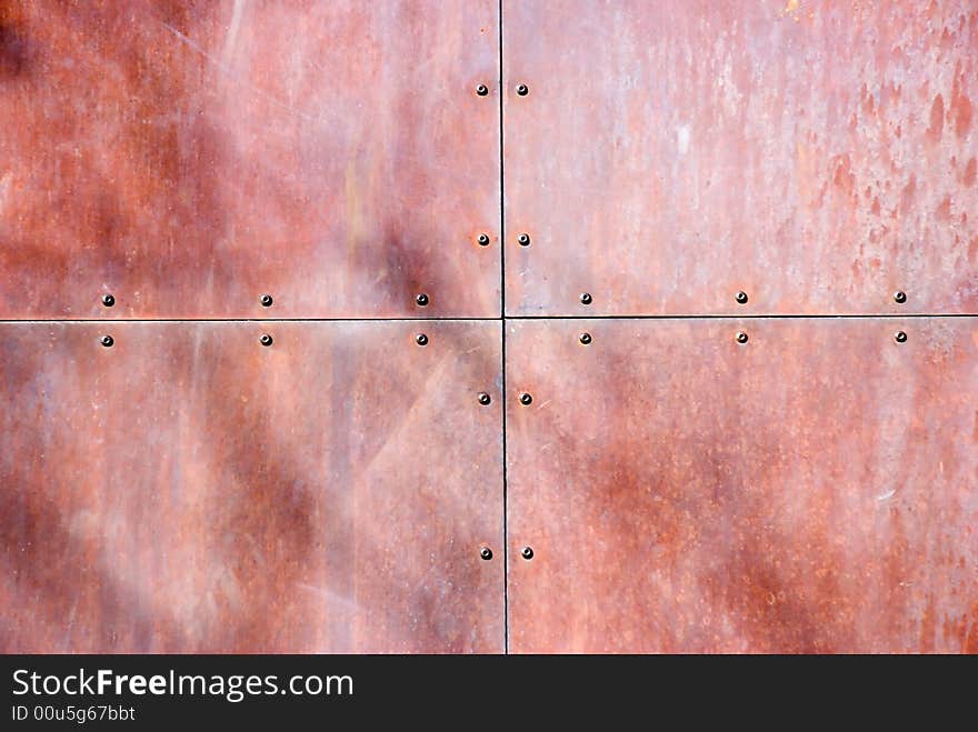 A riveted, rusted piece of sheet metal. A riveted, rusted piece of sheet metal