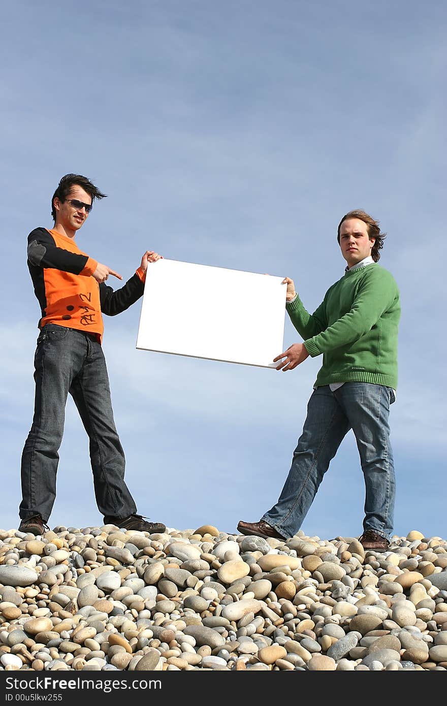 Two Young Men Holding White Card at the beach