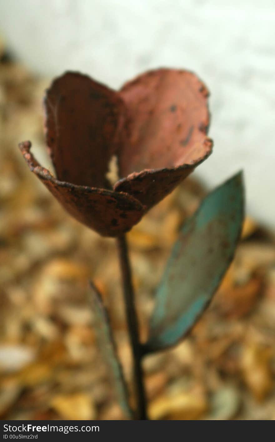 Metal Fake Flower Outside with fallen leaves in the background. Metal Fake Flower Outside with fallen leaves in the background.