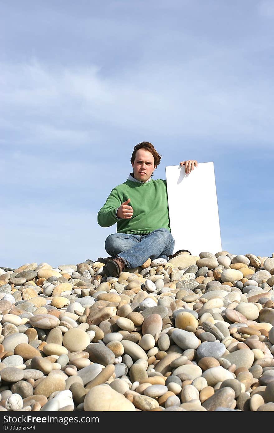 Young Man Holding White Card at the beach