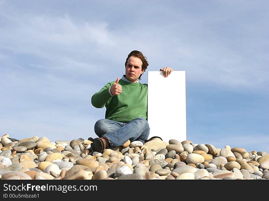 Young Man Holding White Card at the beach