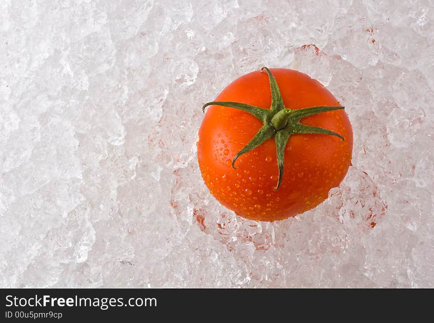 A red ripe tomato on a bed of ice