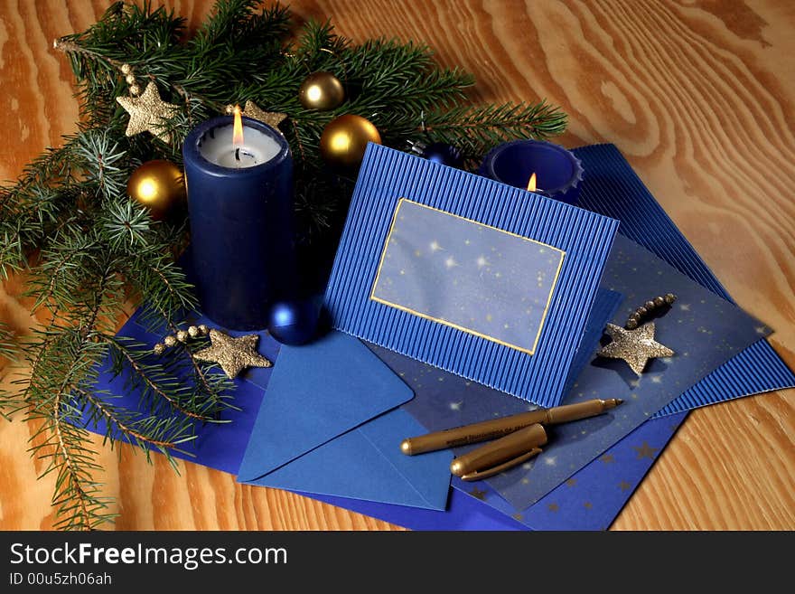 Slill-life with candle and holiday card in tones of gold and blue. Slill-life with candle and holiday card in tones of gold and blue.