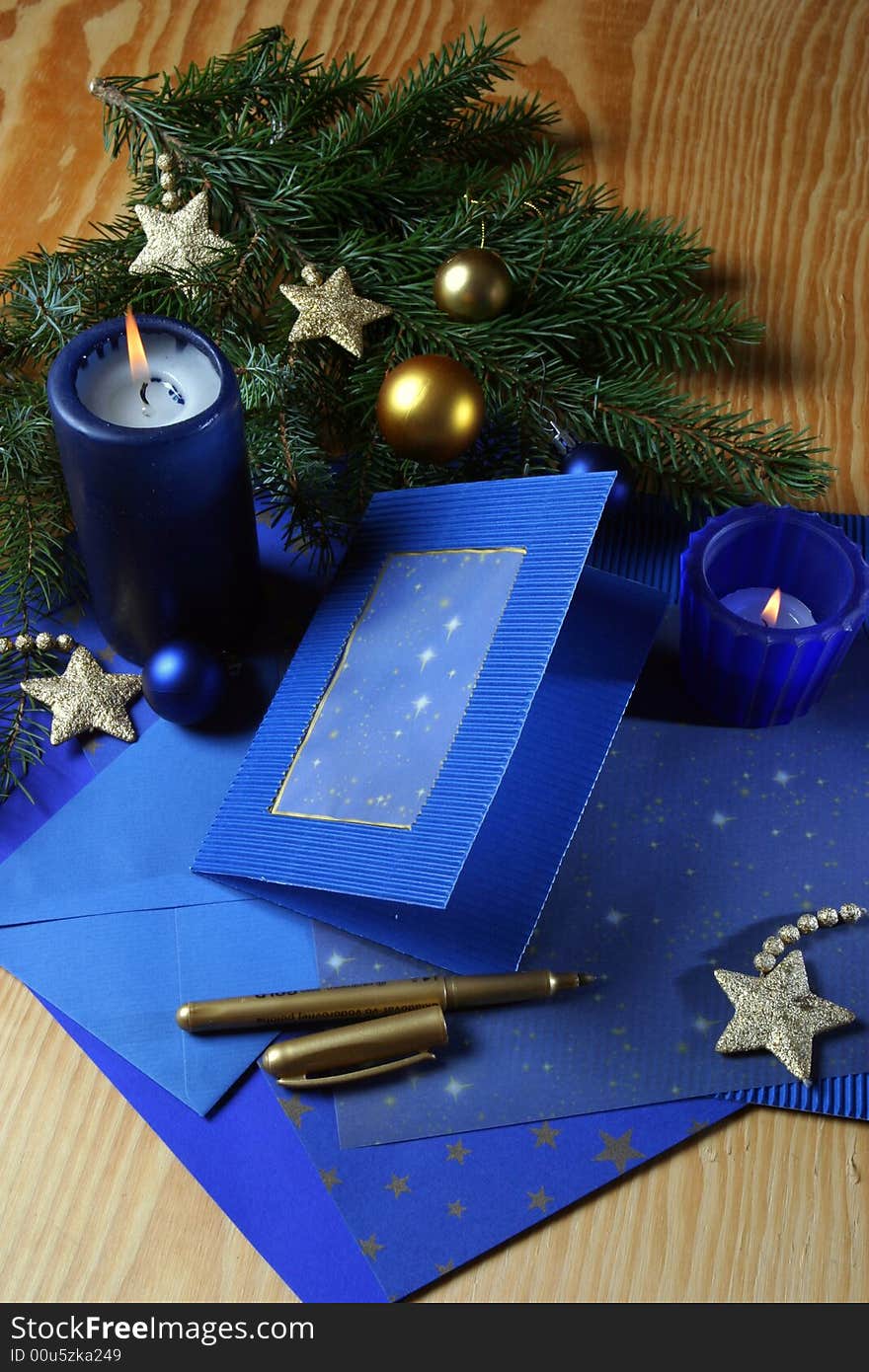 Slill-life with candle and holiday card in tones of gold and blue. Slill-life with candle and holiday card in tones of gold and blue.