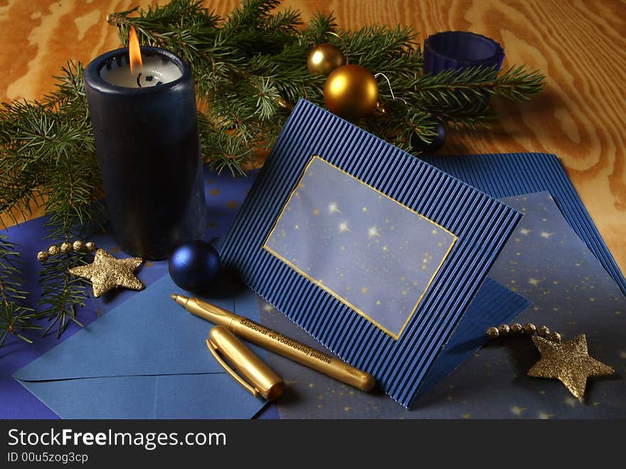 Slill-life with candle and holiday card in tones of gold and blue. Slill-life with candle and holiday card in tones of gold and blue.