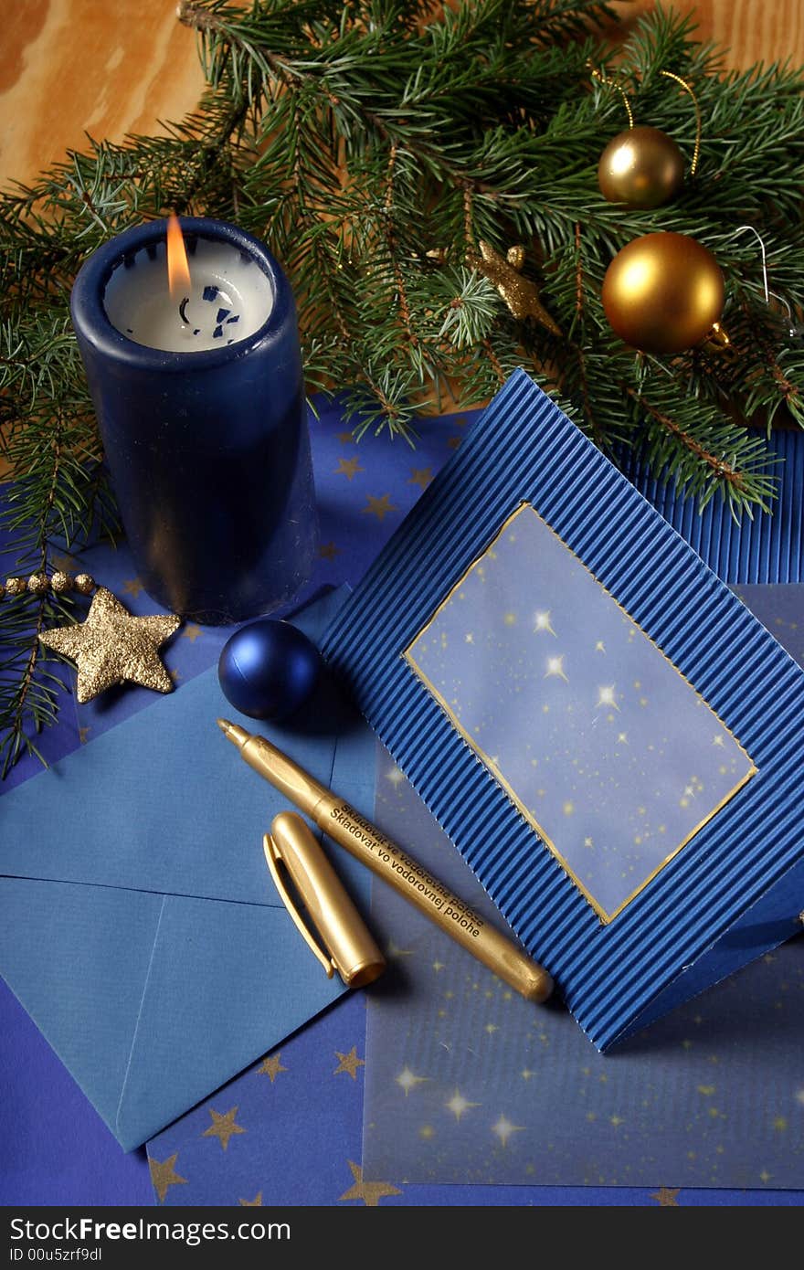 Slill-life with candle and holiday card in tones of gold and blue. Slill-life with candle and holiday card in tones of gold and blue.