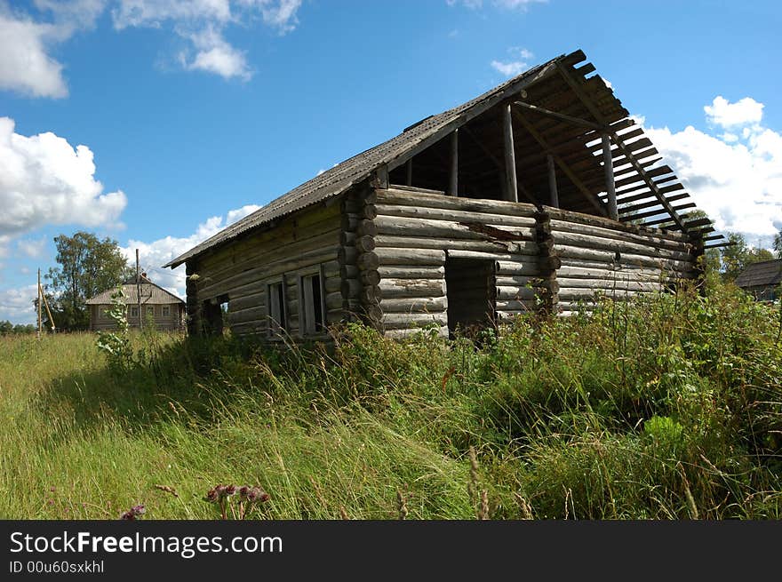 Old broken wooden hut in russian village, green grass around. Old broken wooden hut in russian village, green grass around