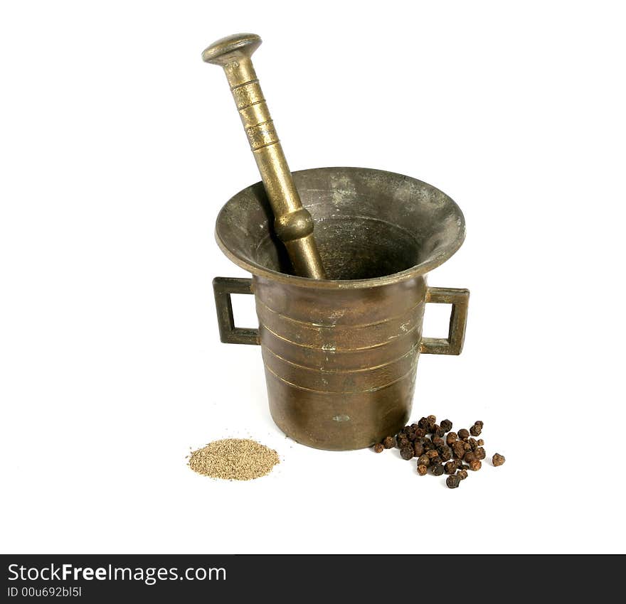 Mortar and pestle crushing pepper, with pepper spread around