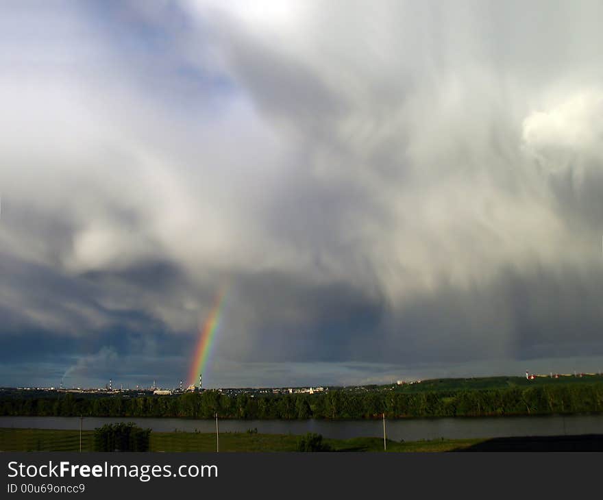 Storm clouds landscape with rainbow