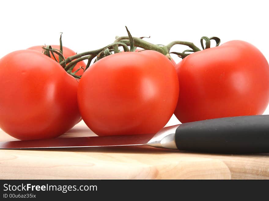 Fresh picked red vine tomatoes and knife white background. Fresh picked red vine tomatoes and knife white background