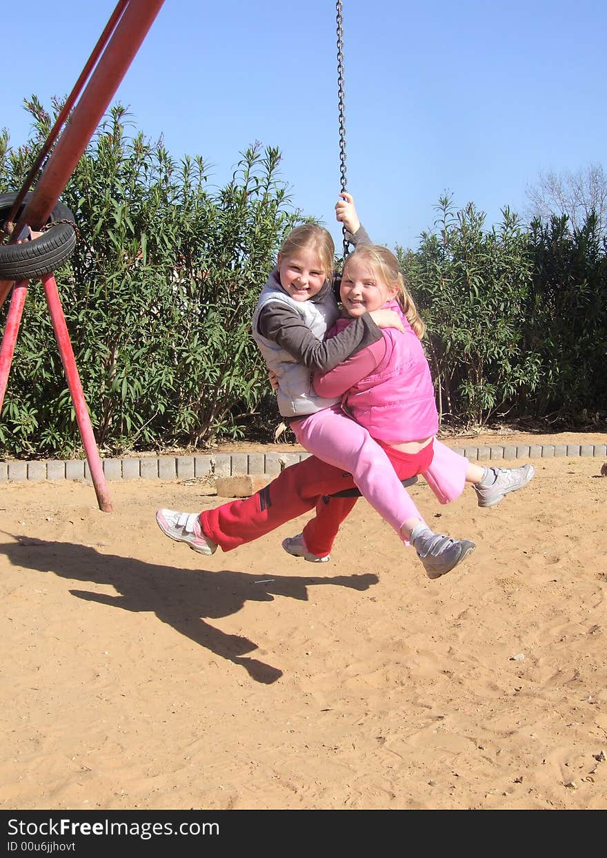 Twin sisters together on seesaw -a console with chain