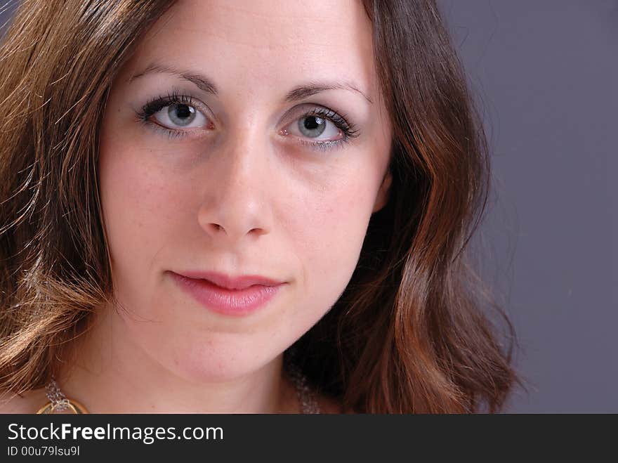 Portrait of attractive young lady on grey background