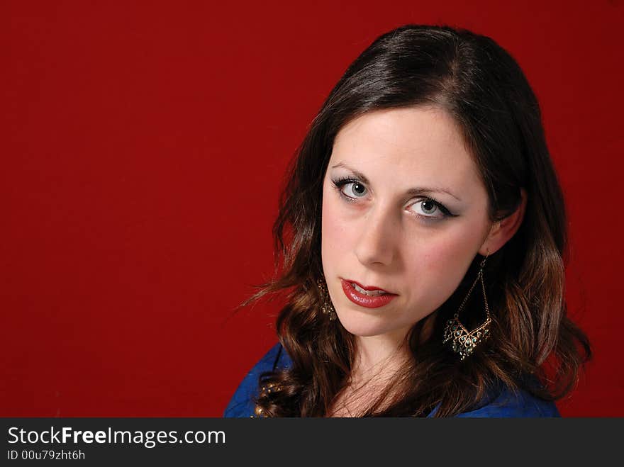 Portrait of attractive young lady in blue dress on red background