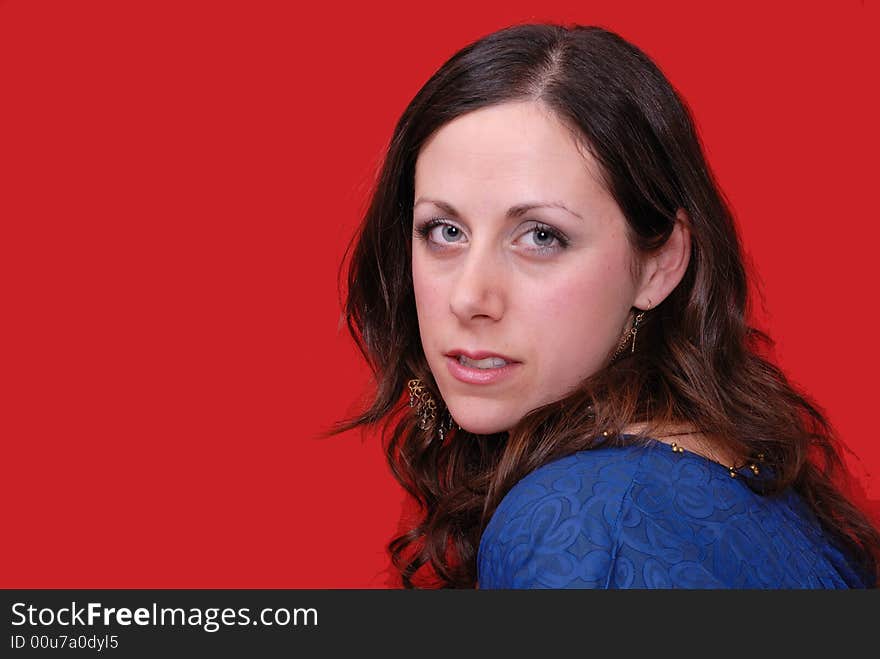 Portrait of attractive young lady in blue dress on red background