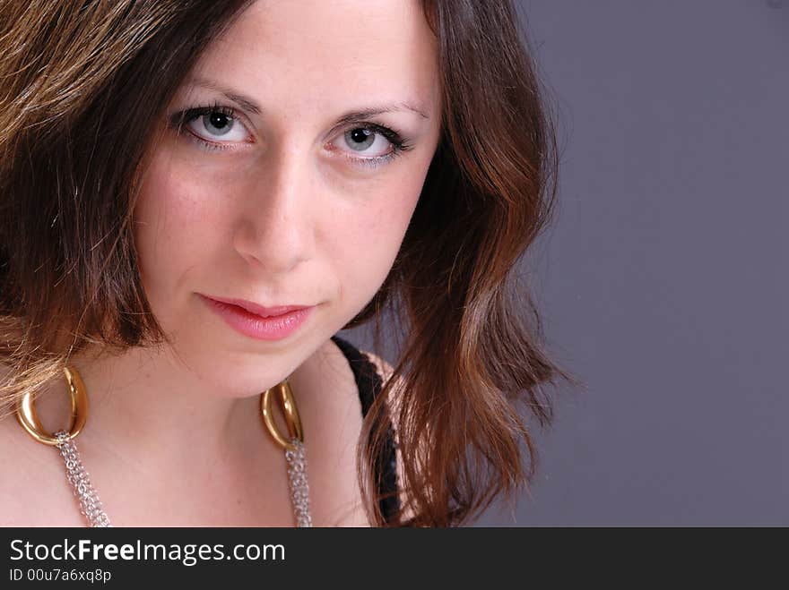 Portrait of attractive serious young lady on grey background. Portrait of attractive serious young lady on grey background