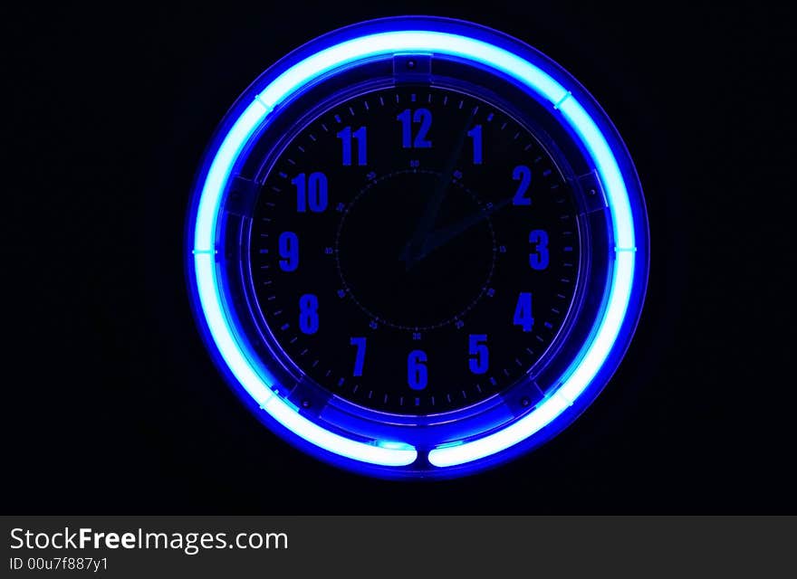 A bright blue clock glowing against a black background, hands are barely visible.  Sometimes you don't really want to know the time. A bright blue clock glowing against a black background, hands are barely visible.  Sometimes you don't really want to know the time.