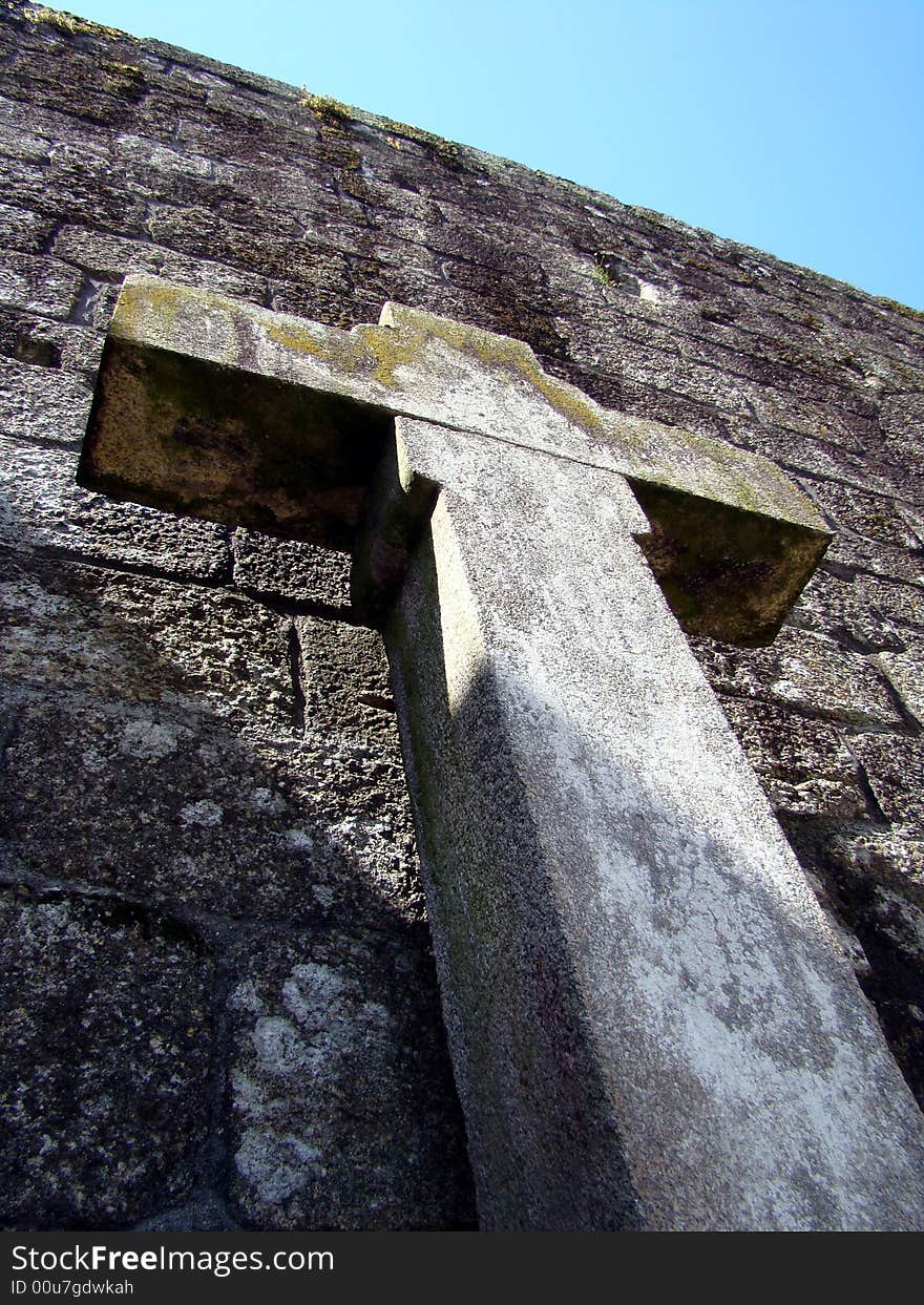 Cross floating over Barcelos castle wall towards the sky escaping from shadows. Cross floating over Barcelos castle wall towards the sky escaping from shadows