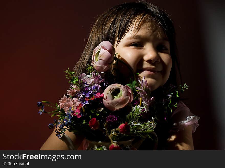 Little girl smiling hiding behind a bunch of flowers. Little girl smiling hiding behind a bunch of flowers