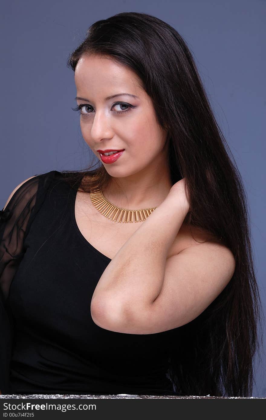 Portrait of seductive glamorous woman wearing ornate necklace and evening wear. Portrait of seductive glamorous woman wearing ornate necklace and evening wear