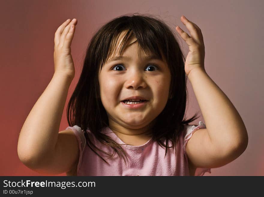 Young girl holding her hands in the air looking surprised. Young girl holding her hands in the air looking surprised