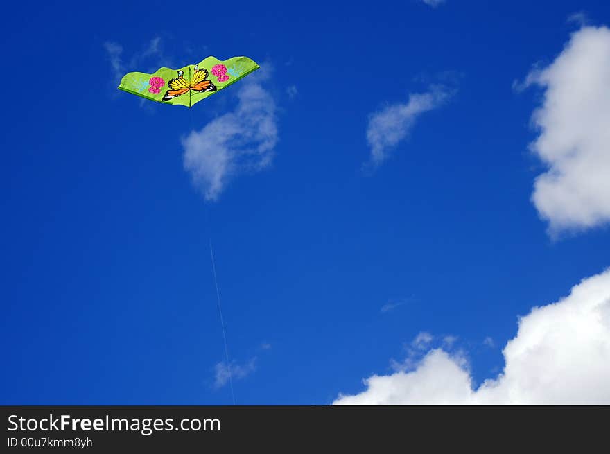 Green kite against blue sky