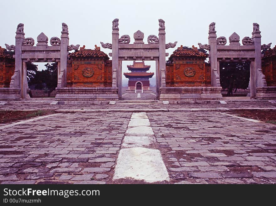 Glazed gate at the qing west tombs. purlins and bracket sets carved out of one piece of stone. the bracket sets and tie beams are engraved with designs of flowers and animals.