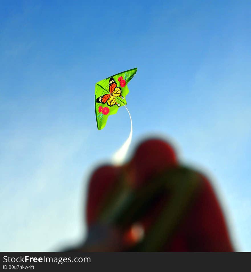 Green kite against blue sky. Green kite against blue sky