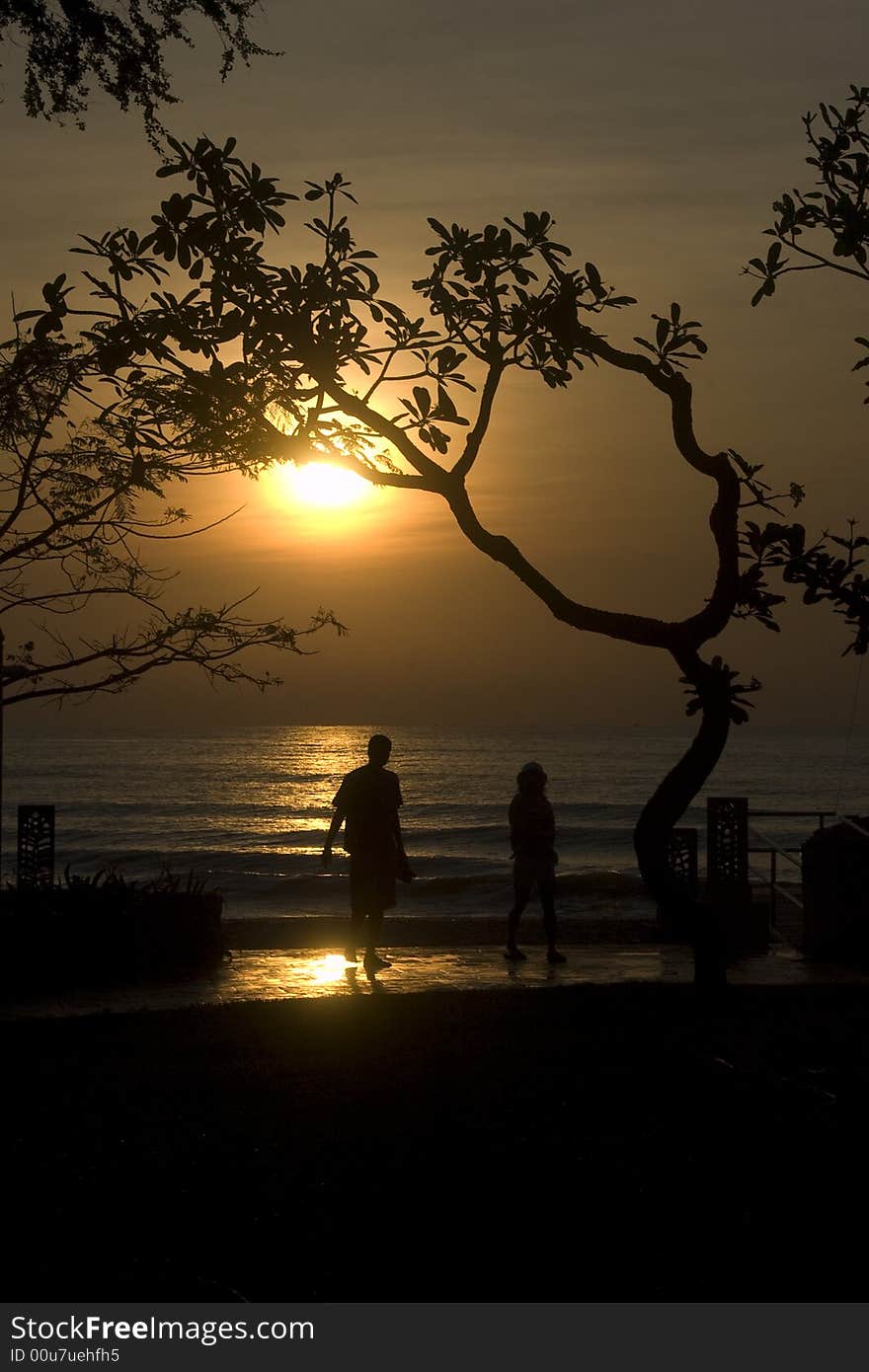 Lover walk on the beach at the early sunrise morning,photo is silhouette. Lover walk on the beach at the early sunrise morning,photo is silhouette.