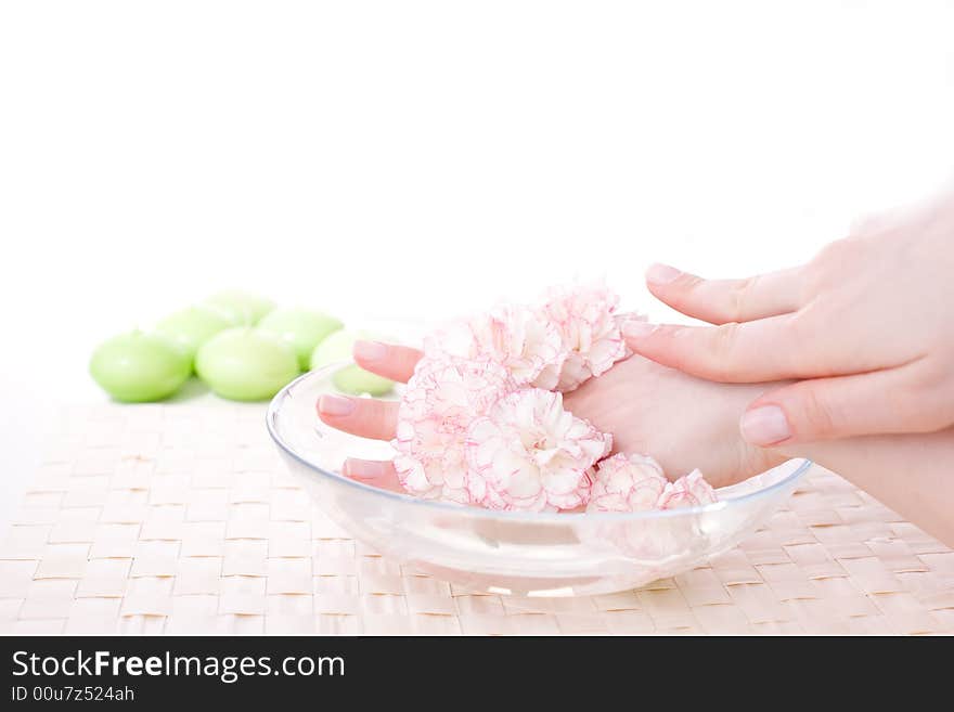 Beutiful female hands in bowl full of water and flower / bodycare