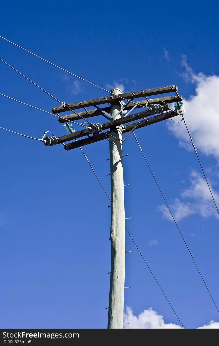 Power lines encroaching on a pristine blue sky. Power lines encroaching on a pristine blue sky