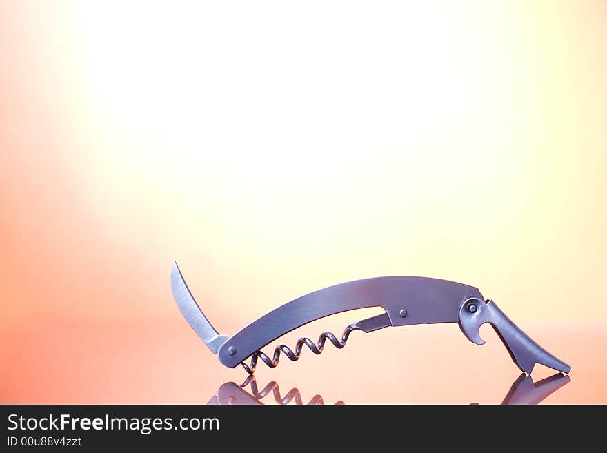 A metal corkscrew on the orange background / copyspace