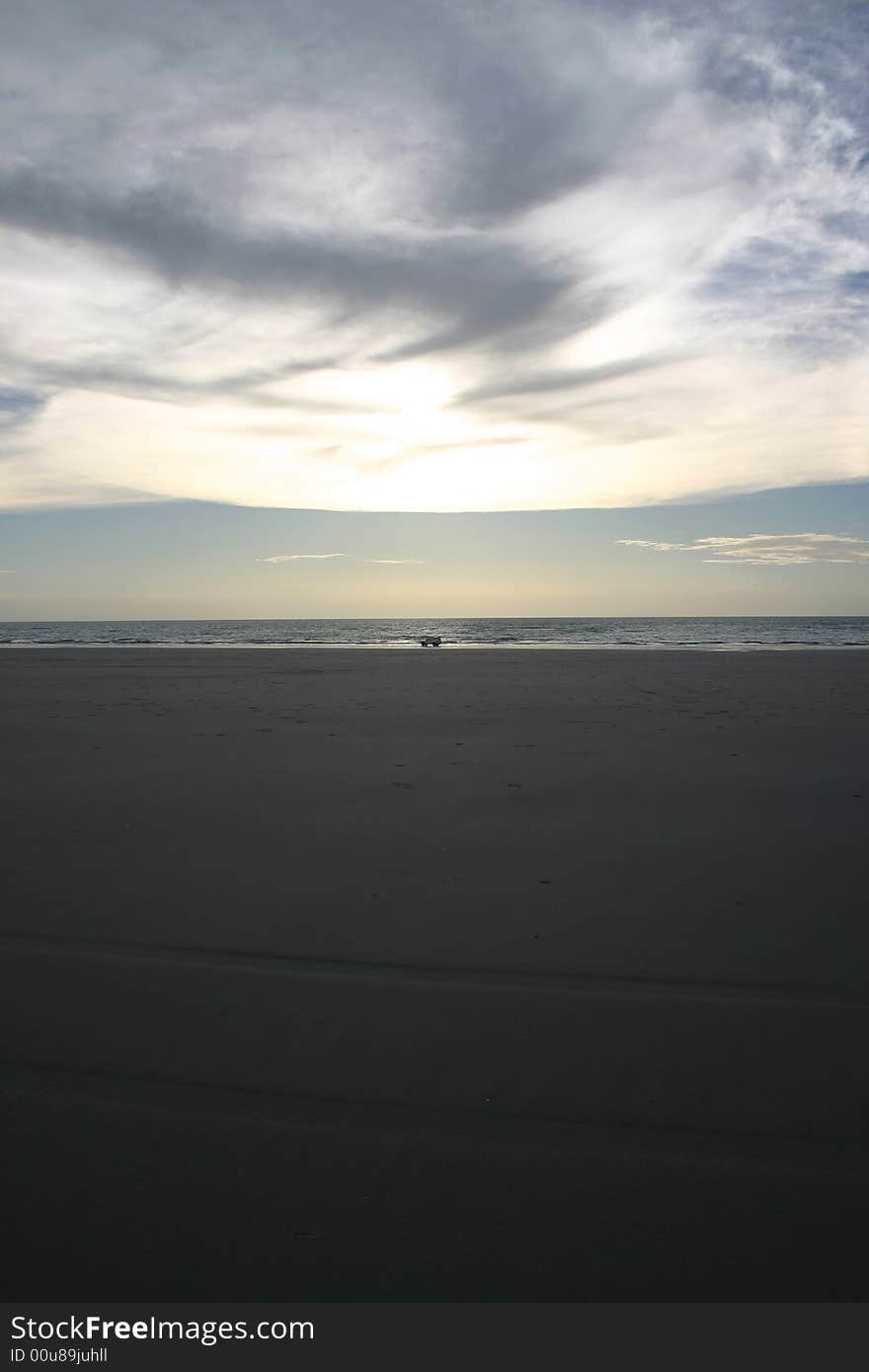 Silhouette of a car driving on a sandy beach. Australia. Silhouette of a car driving on a sandy beach. Australia.