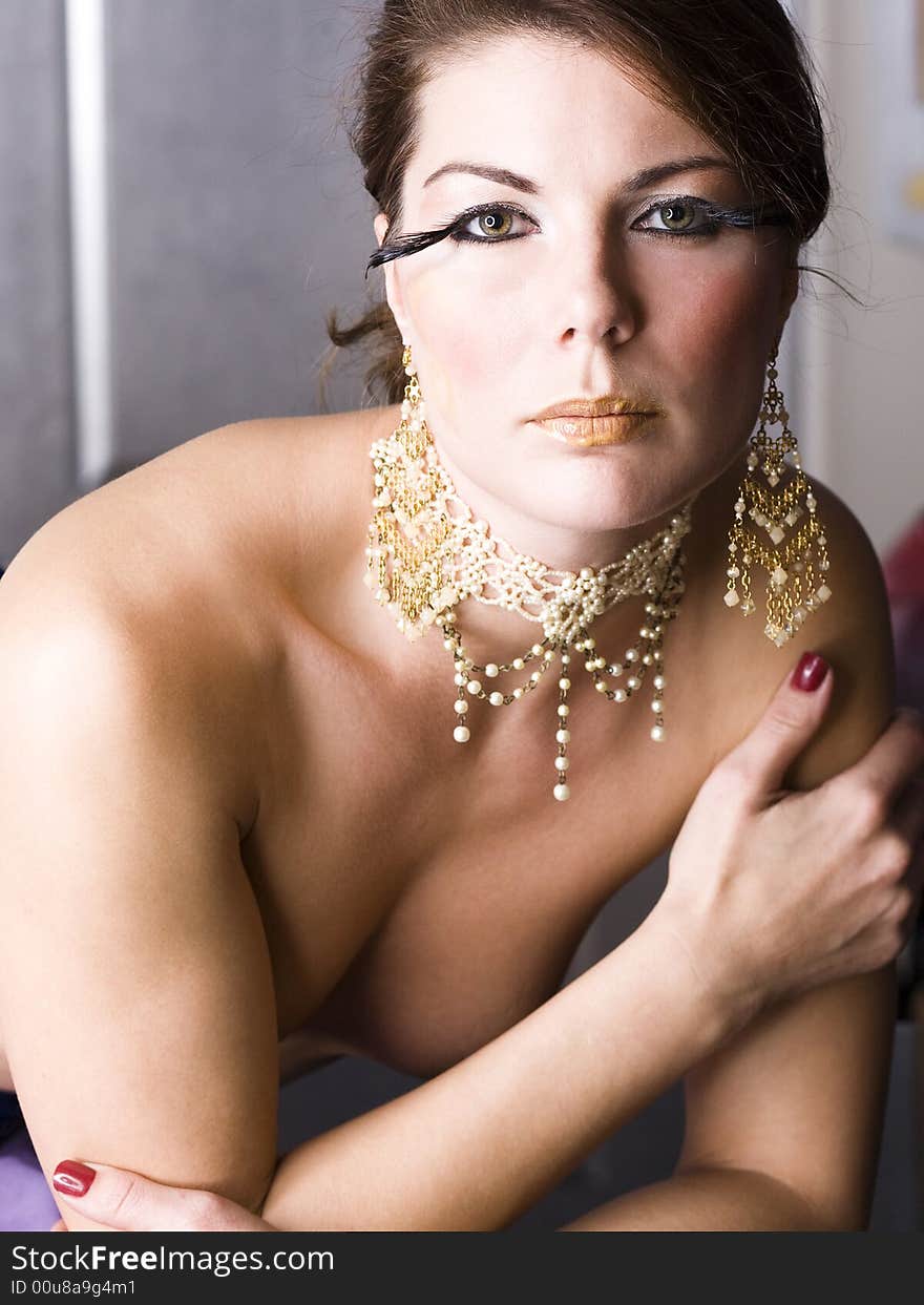 Close up of a young woman wearing a fancy necklace and ear rings. Close up of a young woman wearing a fancy necklace and ear rings